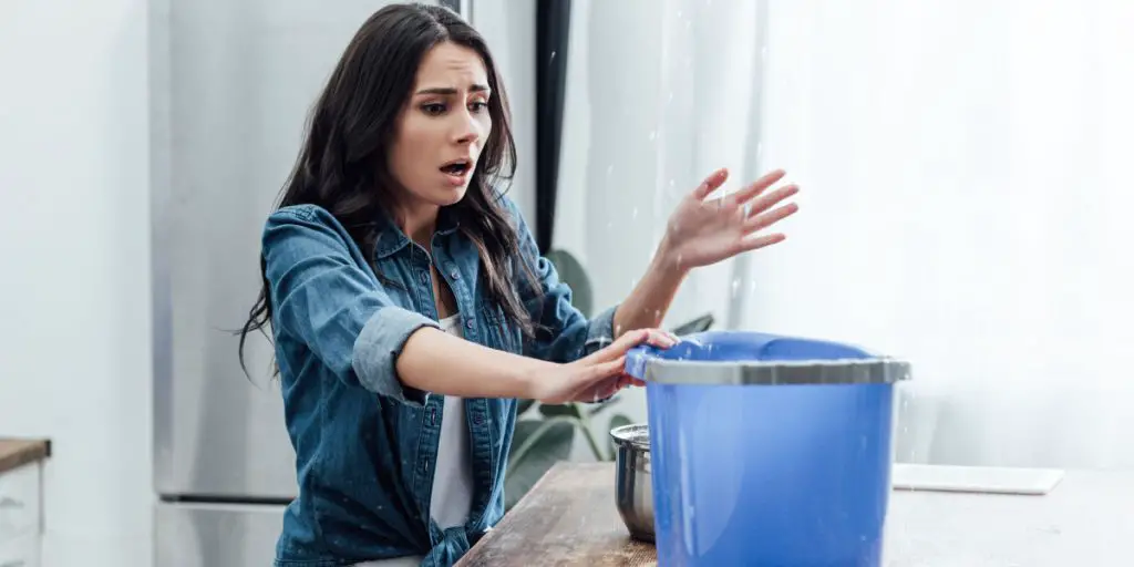 Woman catching water in a bucket