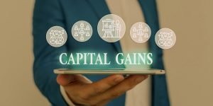 A person in a suit holds a tablet with the glowing text "Capital Gains" and icons of people surrounding it.