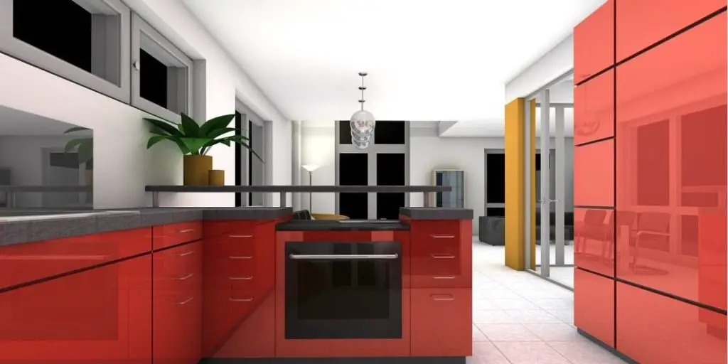 Modern kitchen with glossy red cabinets, a central oven, and a sleek countertop exemplifies modern kitchen design. A pendant light hangs above, complemented by a plant in the corner. White walls and large windows enhance the space with natural light.