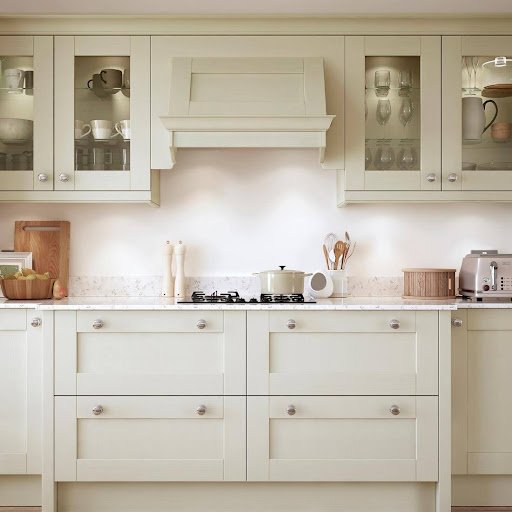 A modern, upgraded kitchen with cream cabinetry, a gas stove, glass fronted upper cabinets, utensils in a jar, and small appliances on a white countertop—perfect for letting your property faster.